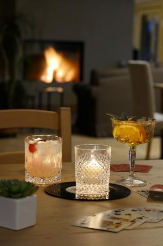 a table with two glasses and a candle on it at Relais Rossar Boutique Hotel Garda & Hills in Costermano sul Garda