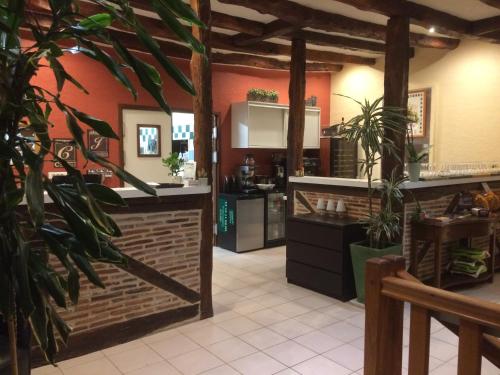 a kitchen with orange walls and a counter with plants at Auberge des 7 Tours in Martel