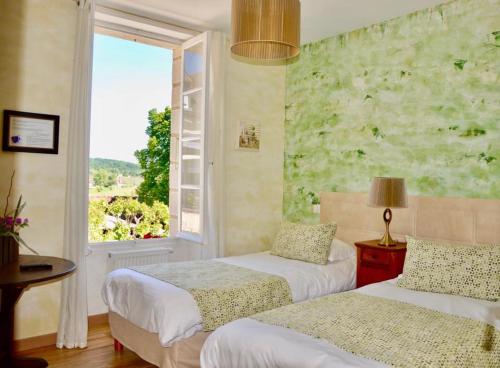 a bedroom with two beds and a window with a view at Auberge des 7 Tours in Martel