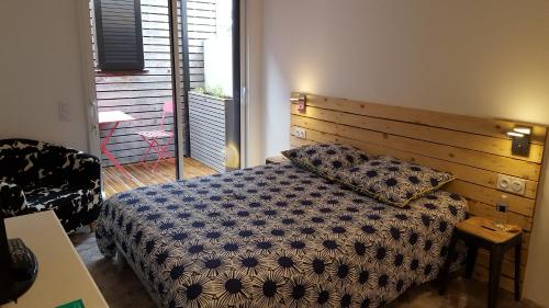 - une chambre avec un lit et une tête de lit en bois dans l'établissement Angers Green Lodge, à Angers