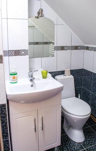 a bathroom with a white sink and a toilet at Home Hotel in Kamianets-Podilskyi