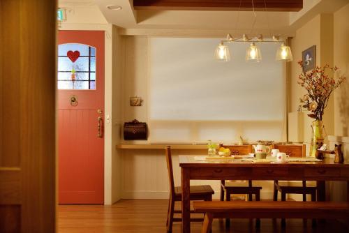 a kitchen with a table and a red door at Good day in Hualien City