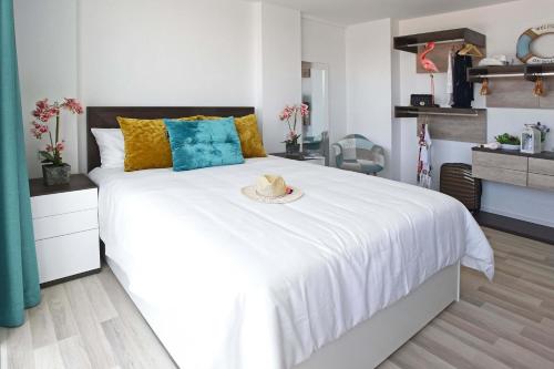 a bedroom with a white bed with a hat on it at Beyond Amadores C&H Suite in Amadores