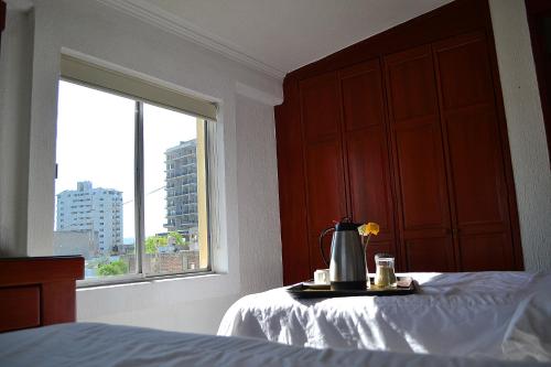 a bedroom with a bed and a window at Hotel Campestre Inn in León