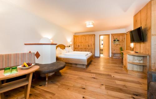 um quarto de hotel com uma cama e uma televisão em Wellness & Sporthotel Alpenhof em Ehrwald