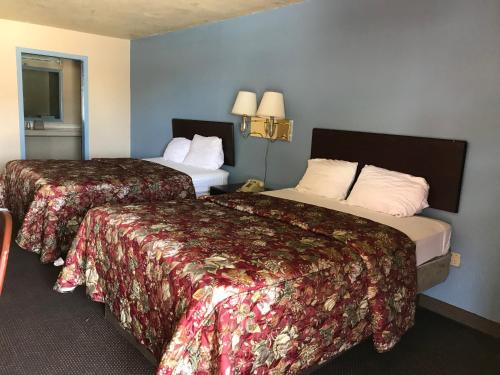 a hotel room with two beds in a room at Deluxe Inn Kilgore in Kilgore