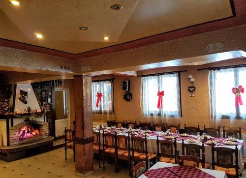 a banquet hall with tables and chairs and a fireplace at Къща за гости "Орлец" in Popovo