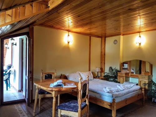 a bedroom with a bed and a wooden table at Къща за гости "Орлец" in Popovo