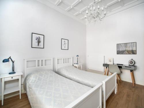 a white bedroom with a bed and a desk at City Apartments Siegburg Studios in Siegburg