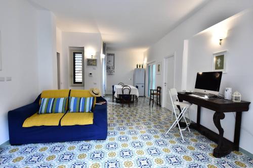- un salon avec un canapé bleu et un bureau dans l'établissement Il Gelsomino Amalfi, à Amalfi