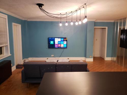 a living room with a couch and a tv on a blue wall at Blue Penthouse in the City in Atlanta