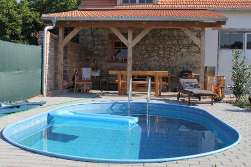 a blue pool with a gazebo in a backyard at "U Čápa" Krásný apartmán v Sedleci in Sedlec