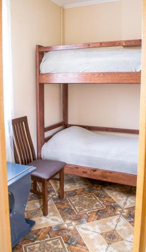 a room with two bunk beds and a chair at Home Hotel in Kamianets-Podilskyi