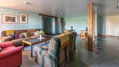 a living room with two couches and a table at Oitme Hostel in Oitme