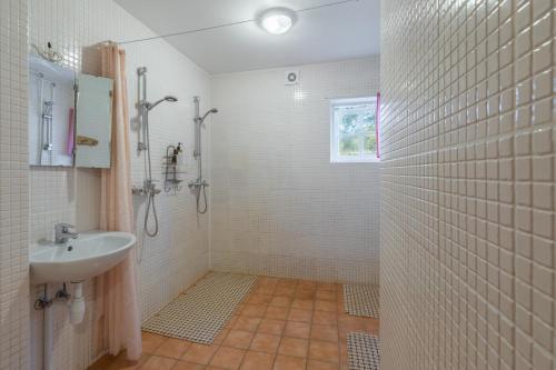 a white bathroom with a sink and a shower at Oitme Hostel in Oitme