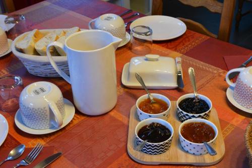 a table with dishes of food and utensils at Maison D'hôtes Du Landersbach in Sondernach