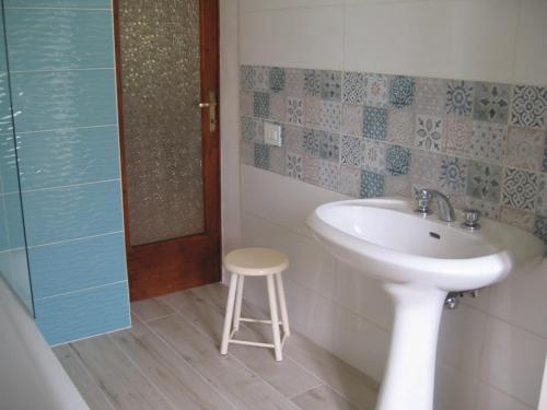 a bathroom with a sink and a stool in it at Villa with River Access in Cocciglia