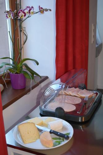 a table with a tray of cheese and a plate of food at Maison D'hôtes Du Landersbach in Sondernach