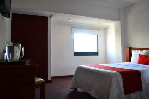a hotel room with a bed and a window at Hotel Campestre Inn in León