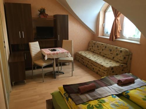 a bedroom with a bed and a table and a couch at David Apartman in Gyula