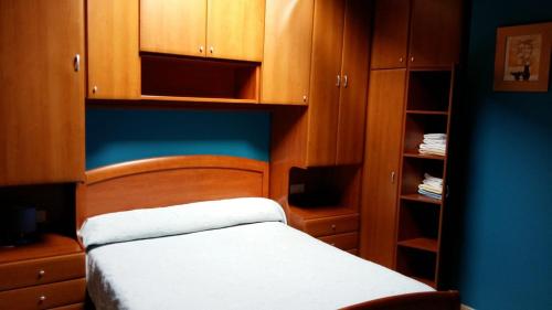 a small bedroom with a bed and wooden cabinets at Chalet "El Bosque" 5 habitaciones in Nueva de Llanes