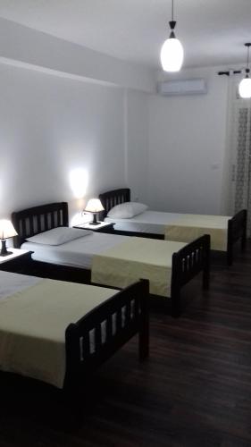 a room with two beds and two lamps in it at Vladimir Estate Hotel in Gjirokastër