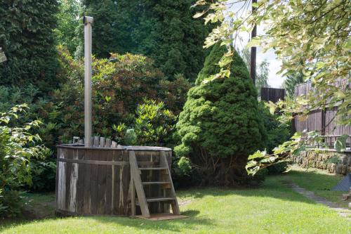 a wooden barrel with a pole in a yard at Penzion Signum Laudis in Velké Hamry