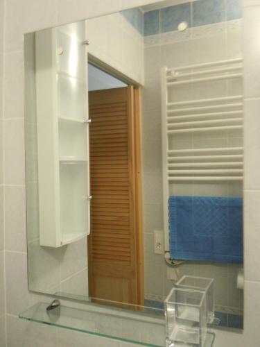 La salle de bains est pourvue d'un miroir, d'un lavabo et d'une chaise. dans l'établissement Résidence Le Méditerranée, à Menton