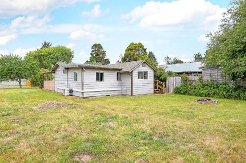 a small white house in a yard at Crabbin Cabin - You Won't Be Crabby After Staying Here! in Westport