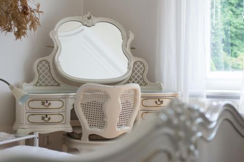 a white dresser with a mirror on top of it at Penzion Signum Laudis in Velké Hamry
