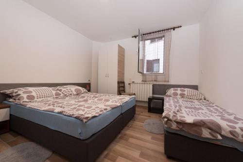 um quarto com 2 camas e uma janela em Apartman Sigurnjak em Matulji
