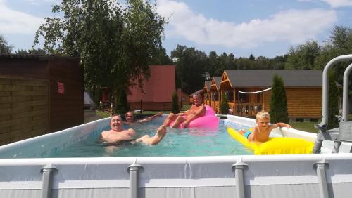 a group of people sitting in a swimming pool at Domki letniskowe ROSSA in Jarosławiec