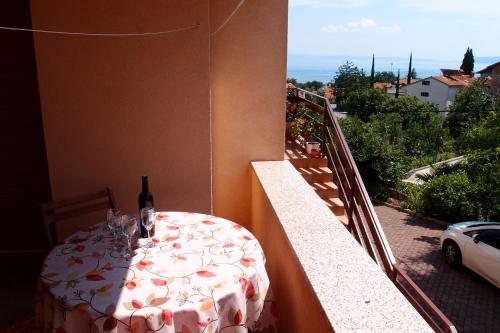 un tavolo con una bottiglia di vino sul balcone di Villa Lina a Ičići