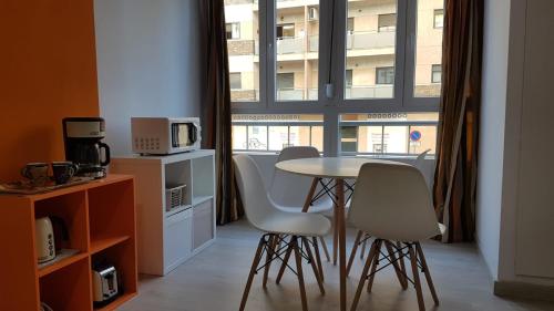 トレモリノスにあるApartamento Silviaの窓のある部屋(テーブル、椅子付)
