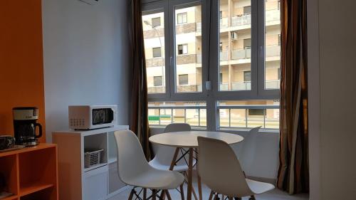 トレモリノスにあるApartamento Silviaの窓のある部屋(テーブル、椅子付)