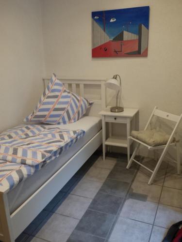 1 dormitorio con 1 cama, 1 silla y 1 pintura en Gästehaus am Kloster, en Blieskastel