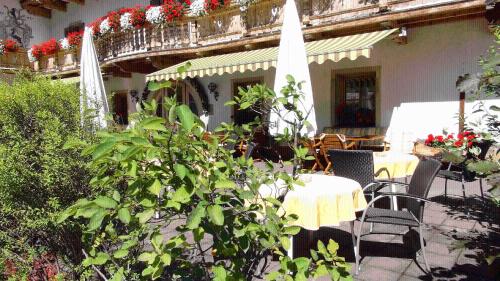 a patio with a table and chairs and umbrellas at Landgasthof Dorferwirt in Oberau