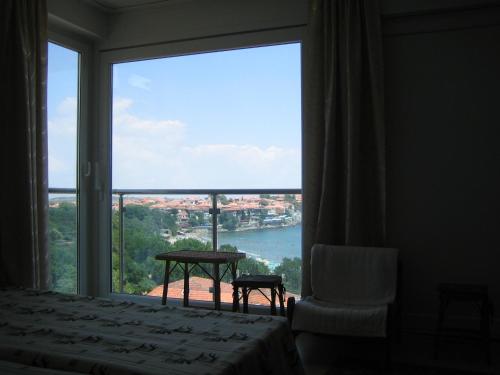 a bedroom with a large window with a view of the water at Guest House Fanari in Sozopol