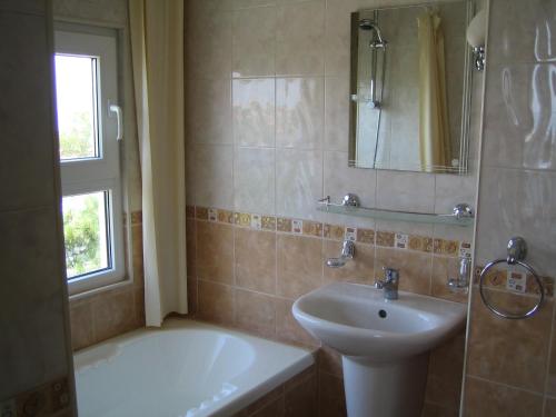 a bathroom with a sink and a bath tub and a sink at Guest House Fanari in Sozopol