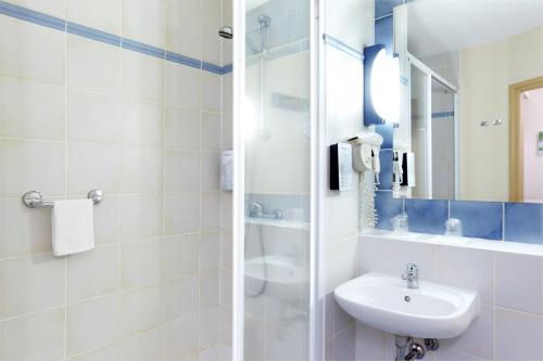 La salle de bains blanche est pourvue d'un lavabo et d'un miroir. dans l'établissement Campanile Hotel & Restaurant Gent, à Gand