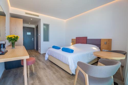a bedroom with a bed and a table and chairs at Protaras Plaza Hotel in Protaras