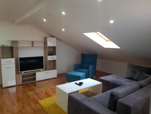 a living room with a couch and two blue chairs at Family Apartments in Zaječar