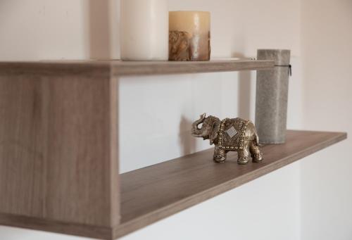a small elephant figurine sitting on a shelf at Family Apartments in Zaječar