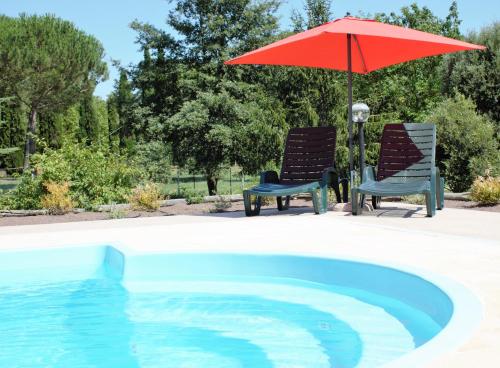 two chairs and an umbrella next to a swimming pool at Il Profumo della Natura B&B in Oriolo Romano