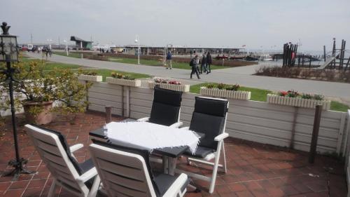 een tafel en stoelen op een patio met uitzicht op het strand bij Ferienwohnung Ol Komede Wai 12c in Helgoland
