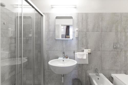 a bathroom with a sink and a glass shower at Interamnia Boutique Hotel in Comunanza