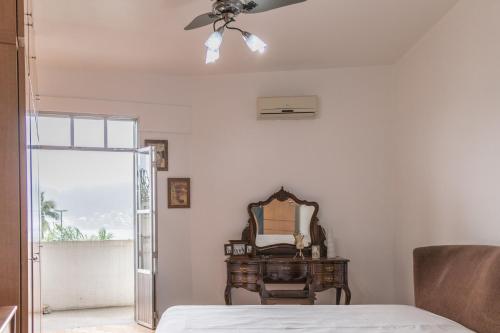 a bedroom with a ceiling fan and a mirror at Apartamento Seaviews in São Vicente