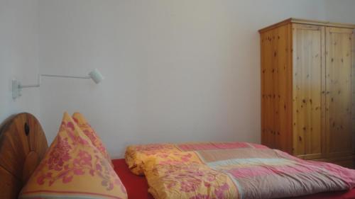 a bedroom with a bed and a wooden cabinet at Ferienwohnung Ol Komede Wai 12c in Helgoland