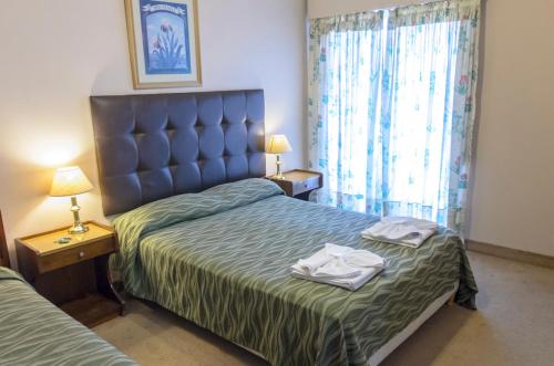1 dormitorio con 1 cama con 2 toallas en Hotel Marydor en La Falda