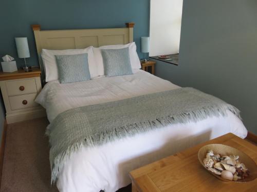 a bedroom with a large bed with a wooden table at Garth Engan Private Self Contained B&B with Garden Area in Llanbedr